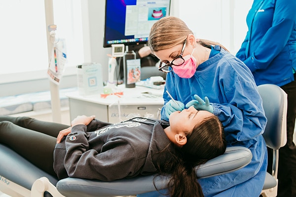 Orthodontic team member using digital scanning technology with a patient in a treatment chair, representing comfortable iTero digital impressions at Griffin Orthodontics, Vernon, CT 06066.